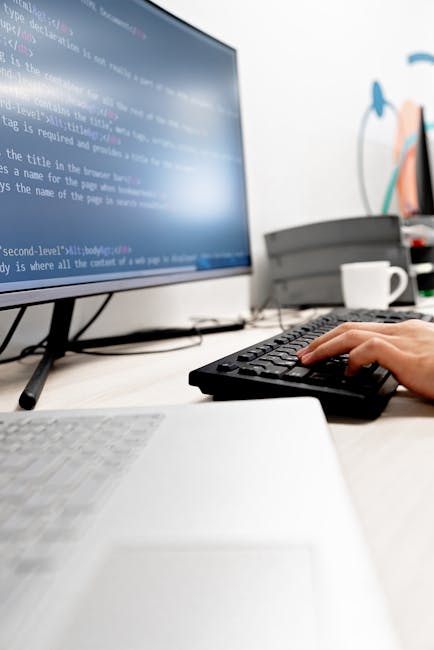 Close-up image of a computer screen displaying lines of programming code with HTML tags, class attributes, and navigation buttons visible on the dark background. The focus is on the text editor, where